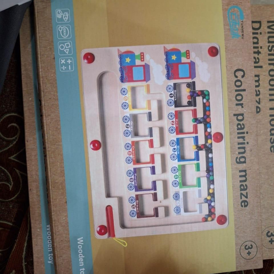 Colorful maze toy with cardboard packaging on a textured surface